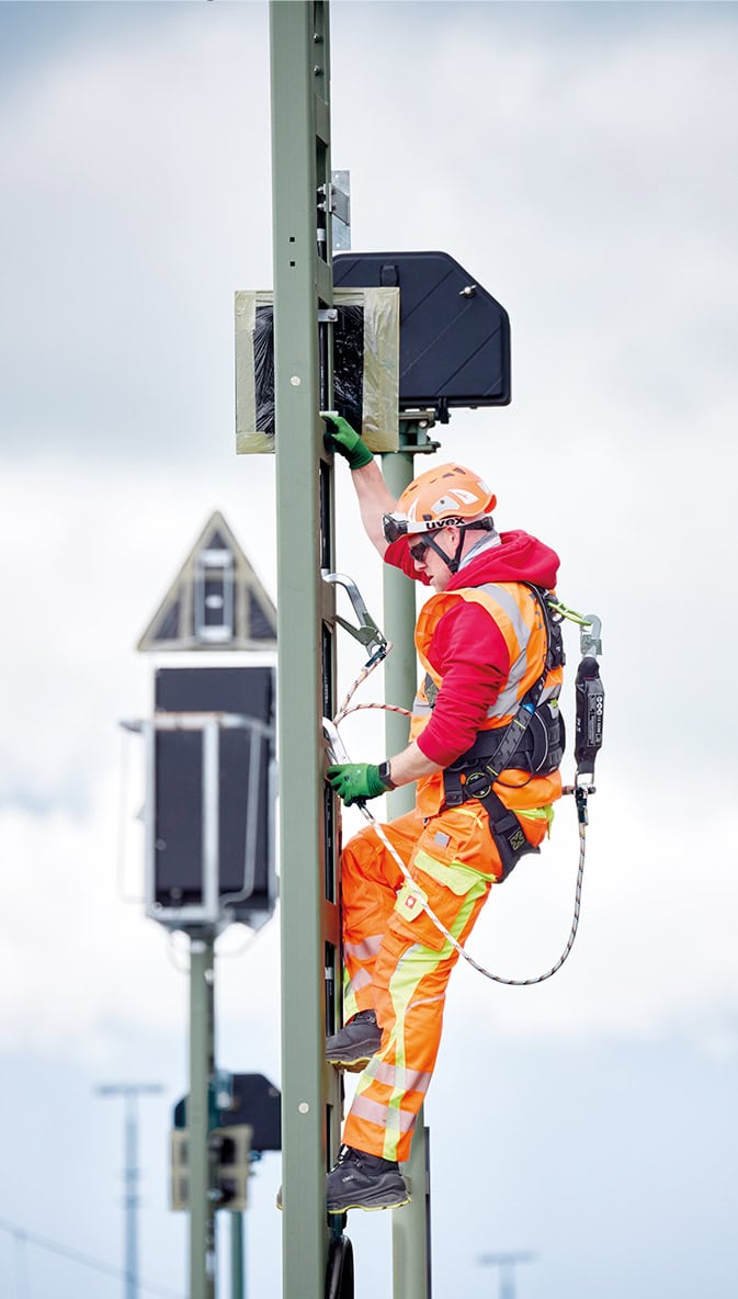 BBL-Techniker mit Sicherung einen Signalmast besteigend